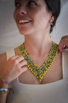 a woman wearing a yellow and green beaded necklace