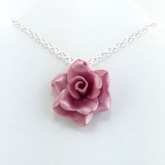 This rose necklace is handmade from Crimson red (light) polymer clay. Each petal is hand formed to make a beautiful rose, no molds are used. The rose measures 1-1/4 inches across (about 3.5cm) and has a silver plated bail. This rose pendant is Made to Order so you will not receive the exact rose pendant that is pictured but it will be extremely similar. The color will be exactly the same but the petals may lay slightly differently. Includes your choice of silver plated necklace. Your rose will c Pink Flower-shaped Necklaces With Roses, Pink Rose Necklaces For Gifts, Rose Jewelry With 3d Flowers For Gift, Handmade Pink Flower Necklace For Wedding, Handmade Rose Necklace For Valentine's Day, Handmade Rose Flower Necklace, Pink Polymer Clay Necklace For Gift, Handmade Rose Wedding Necklace, Pink Polymer Clay Necklace For Gifts