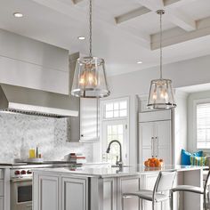 a kitchen with two pendant lights hanging from the ceiling