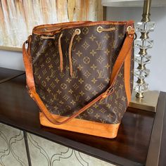 Authentic Louis Vuitton Noe Bucket Shoulder Bag In Mono Canvas **Bag Has Been Authenticated By Proauthenicators ** Gorgeous Vintage Beauty Pre-Loved So You Don't Have To Baby Her. - Golden Honey Patina - Leather Has Normal Wear: Cracks, Wrinkles - Canvas Looks Good With No Visible Cracks. Have The Vachetta Replaced & She'd Be Brand New! - Clean Inside With Minor Spots - Vintage Condition - Date Stamp: A2 882 ** Examine Photos Carefully & Ask For More Before You Buy! Designer Monogram Canvas Bucket Satchel Bag, Monogram Canvas Bucket Shoulder Bag For Errands, Designer Brown Bucket Bag For Travel, Designer Tan Bucket Bag For Travel, Designer Brown Bucket Tote Bag, Designer Brown Satchel Bucket Bag, Luxury Brown Shoulder Bag For Errands, Vintage Brown Monogram Canvas Bags, Luxury Brown Satchel Bucket Bag