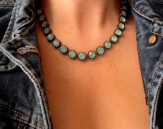 a close up of a person wearing a necklace with blue stones on it's neck