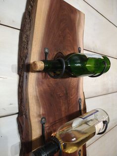 a bottle of wine is hanging on the wall next to a corkscrew holder