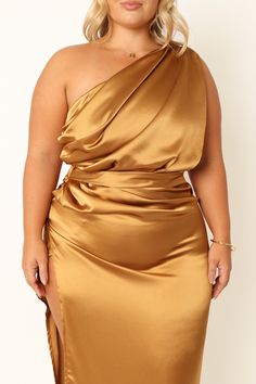 a woman wearing a gold dress with one shoulder and an asymmetrical top