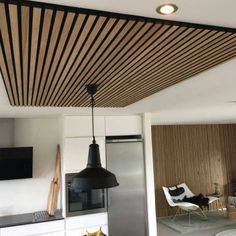 a modern kitchen with white cabinets and black accents on the ceiling, along with wooden slatted ceilings