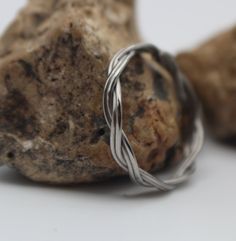 two silver rings sitting on top of a rock