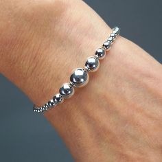 Ball Bracelet 925 Sterling Silver Minimalist Bead * Product Type: Pendants * Material: 100% 925 Sterling Silver * Marked: Stamped 925 * Adjustable length: 17.5 cm - 19.5 cm / 6.88 in - 7.67 in * Diameter ball:10 mm / 0.39 in * Closure: Spring Ring * Weight: Approximately 10 grams * Additional Finish: Hand Polishing * Density: Solid * Item Conditions: New Fact New from the BELDIAMO ESSENCE Collection introduced the beaded silver bracelet. A simple but elegant design, crafted from BELDIAMO Sterlin Classic Silver Round Beads Stretch Bracelet, Classic Adjustable Sterling Silver Stretch Bracelet, Classic Silver Bracelets With 8mm Beads, Classic Adjustable Sterling Silver Bracelet With Spacer Beads, Classic Silver Beaded Bracelets With Sterling Silver Clasp, Classic Sterling Silver Bracelet With Beads, Modern Silver Jewelry With 8mm Beads, Classic Sterling Silver Stretch Bracelet, White Gold Beaded Jubilee Bracelet