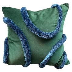 a green pillow with blue trim and two pillows on the front, one in the middle