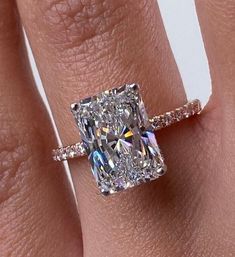 a woman's engagement ring with a cushion cut diamond in the center and pave band