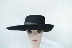 This unique shape black wide-brimmed wool felt hat would be perfect for any special occasion. The measurements are 16 inches by 12 inches. The hat is trimmed with a black grosgrain ribbon band that is removable if you would like to use another band. The shape of this hat is inspired by the actor Billy Porter. The hat will fit up to a 22 5/8 inch head size and has a sizing cord inside to adjust to your head size. Black Wool Felt Hat For Formal Occasions, Formal Black Wool Felt Hat, Black Vintage Fur Felt Fedora, Vintage Black Fur Felt Fedora, Elegant Black High Crown Felt Hat, Black High Crown Felt Hat For Winter, Black Wool Top Hat With Curved Brim, Winter High Crown Black Felt Hat, Elegant Black Wool Fedora