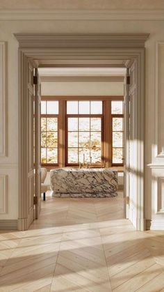 an open door leading to a bathroom with a stone bathtub in the center and windows on either side