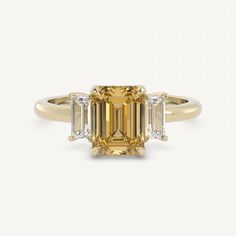 an emerald cut diamond ring with three baguets