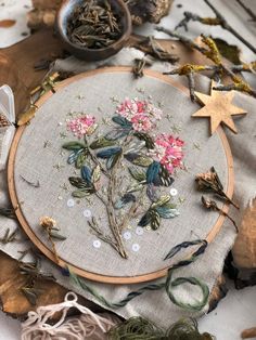 a close up of a embroidery on a piece of cloth with flowers and stars in the background