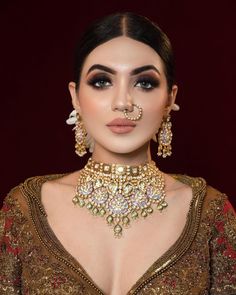 a woman wearing gold jewelry and nose ring