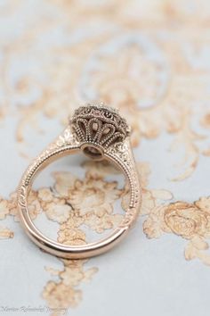 an antique style engagement ring on a floral background