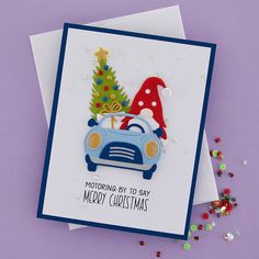 a christmas card with a blue car and santa hat