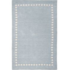 a light blue rug with white dots on the border and a square shape in the middle