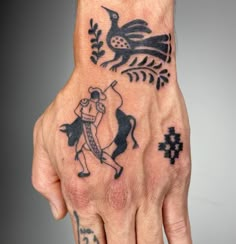 a person with tattoos on their hand holding something