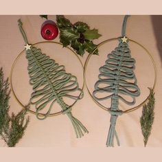 two wire christmas tree ornaments with holly on them