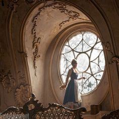 a woman standing in front of a round window