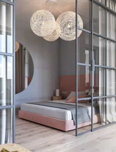 a bed sitting under two hanging lights in a bedroom