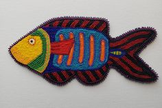 an embroidered fish is shown on a white surface