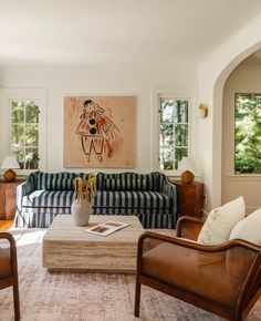 a living room filled with furniture and a painting on the wall