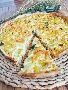 a pizza sitting on top of a wicker basket next to a slice missing from it