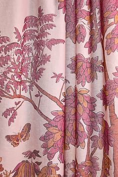 a curtain with pink flowers and birds on it, hanging from the side of a window