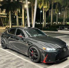 a gray sports car parked in front of some palm trees