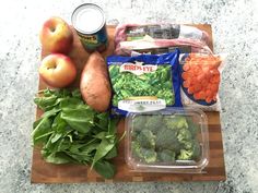 vegetables and fruits are on a cutting board next to a can of broccoli