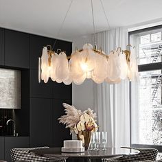 a dining room table with chairs and a chandelier hanging from it's ceiling