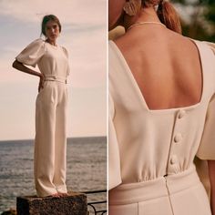 a woman standing next to the ocean wearing a white jumpsuit with buttons on it