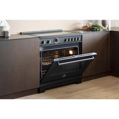 an oven with the door open in a kitchen area that has wood flooring and cabinets