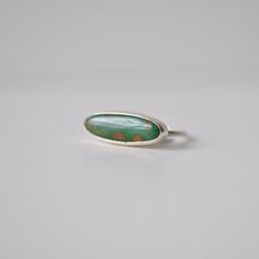 This natural turquoise from Nevada has a lovely grass green color with some light brown inclusions to add some visual interest. Skinny oval shaped cabochon is set horizontally in a simple handcrafted stacker ring setting. .925 Sterling Silver Size 6 Top measures approximately 7mm x 20mm *Only ONE available Great alone or paired with friends! Horizontal Gemstone Ring, Green Oval Opal Ring, Green Oval Turquoise Gemstone Ring, Sterling Silver Turquoise Ring Oval Cabochon, Turquoise Oval Cabochon Opal Ring, Handmade Green Oval Cabochon Ring, Handmade Green Emerald Oval Cabochon Ring, Minimalist Green Oval Jewelry, Oval Turquoise Chrysoprase Ring