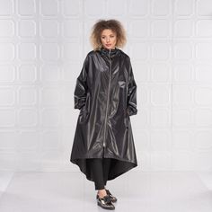 "Black Raincoat Women, Cyberpunk Rain Jacket, Hooded Cape Coat This cyberpunk rain jacket has an asymmetrical design longer on the back and shorter on the front. It has long double side zipper along with two side pockets and long belt to adjust the waistline to your personal needs and fashion style. The elastic finishes on the sleeve and the light fabric make this rain coat a \"must have\" fashion piece for the season. The model in the picture is 168cm. ⅼ 5.6 ft. tall and is wearing size S / col Long Raincoat For Winter Streetwear, Winter Streetwear Long Raincoat, Long Fall Raincoat For Streetwear, Fall Streetwear Long Coat Raincoat, Oversized Hooded Raincoat For Rainy Season, Fall Streetwear Long Raincoat, Urban Style Hooded Raincoat For Rainy Weather, Urban Hooded Raincoat For Rainy Weather, Fall Hooded Raincoat With Detachable Hood