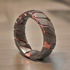 a ring made out of metal sitting on top of a wooden table