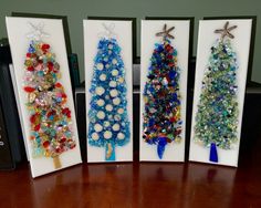 three christmas trees made out of glass beads on a wooden table next to a speaker