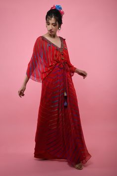 Red kaftan tunic with all-over multicolored Leheriya print, embroidered V-neckline and asymmetric hem. Comes with braided tie-up belt.
Component: 2
Printed, Embroidered
Neckline: V-Neck
Sleeve Length: Three Quarter
Fabric: Georgette
Color: Red
Asymmetric hem
Braided belt with tassels
Note: The inner slip and headscarf worn by the model is not for sale - Aza Fashions Bollywood Style V-neck Party Kaftan, Summer Festive V-neck Kaftan, V-neck Kaftan For Party And Festivals, Multicolor V-neck Kurta With Dupatta, Bohemian Designer Kaftan For Summer, Bollywood Style V-neck Kaftan For Festive Occasions, Bollywood Style V-neck Festive Kaftan, Bohemian Designer Summer Kaftan, Festive Bollywood V-neck Kaftan