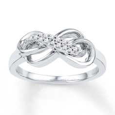 a white gold ring with diamonds in the shape of an intertwined knot on it