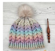 a multicolored knitted hat with a pom - pom on top