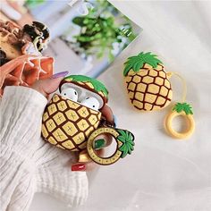 two pineapples are sitting next to each other on a white surface with a magazine in the background