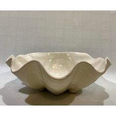 a white ceramic bowl with wavy lines on the bottom and sides, sitting on a table