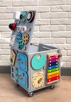 a toy box with many different items in it sitting on a wooden table next to a brick wall