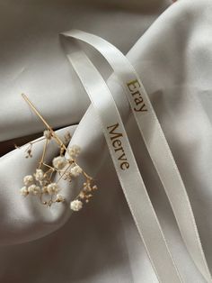 a white ribbon with the words merry new year written on it and some baby's breath