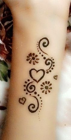 a woman's hand with a henna tattoo on her left wrist and the word love written in black ink