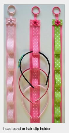 three pink and green hair ties, one with a bow on the end are lined up next to each other