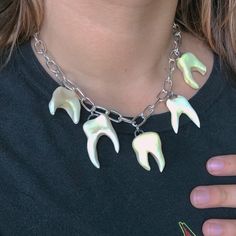 Made to order teeth charm necklaces! A must-have alternative accessory for every occasion!  These human teeth charms are individually crafted by me from natural Versa ceramic clay, fired in a kiln, painted and glazed, then fired again in a kiln at 2,000 degrees to achieve a hard, durable, smooth & stone-like texture. Each made-to-order necklace includes five unique ceramic teeth charms, dangling across shiny, silver stainless steel chunky, oversized chain for a gothic, punk look.  Sizes;  Choker length- 15-16 inches Medium chain length- 17-18 inches Long chain length- 19-20 inches gothic jewelry y2k alternative teeth tooth jewelry oddities curiosities made to order clay statement goth alt dollskill pastel goth 90s 2000s chain funky thick asymmetrical silver gold one of a kind unique one of Chunky Chain Jewelry, Silver Clay Jewelry Ideas, Teeth Charms, Teeth Accessories, Jewellery Portfolio, Tooth Fairy Costumes, Ceramic Chain, Teeth Necklace, Sliver Necklace