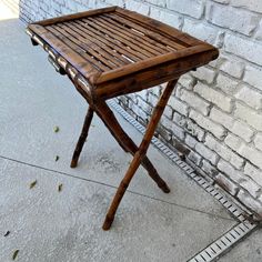 a small wooden table sitting next to a brick wall