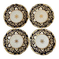 four black and white plates with gold designs