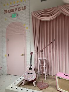 there is a pink room with a guitar on the floor